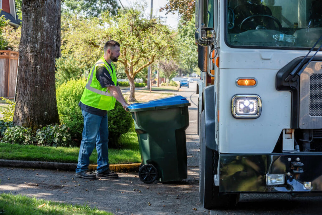 Residential Weekly Garbage Pickup Near Me | Book Today Residential weekly garbage pickup truck near suburban home. Homeowner placing trash bin curbside for weekly collection. Eco-friendly waste collection team handling household trash. Scheduled garbage pickup near me with clean curbside service. Wastigo garbage collection vehicle ready for weekly route.