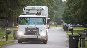 Waste Management Appliance Pickup Schedule | Book Online Waste management appliance pickup team removing old refrigerator Worker lifting washing machine for appliance removal Appliance removal truck at a residential home Eco-friendly recycling of household appliances Scheduling appliance pickup online via mobile device